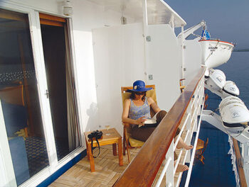 image of woman sitting on Legend cruise balcony,