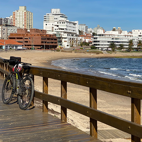 Boardwalk and beach in front of a city skyline in Uruguay. 